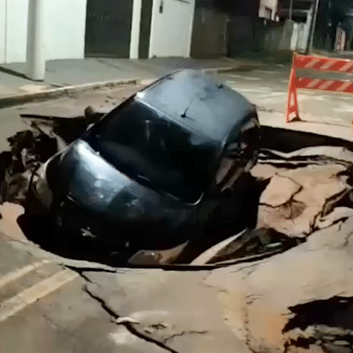 Carro cai em cratera após forte chuva em Coxim